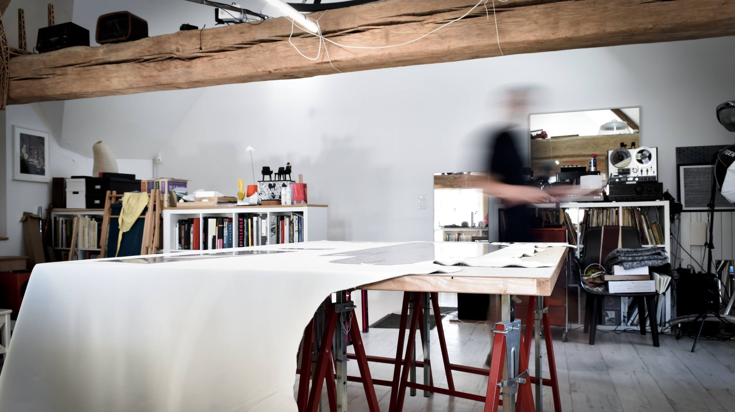 L'atelier : une grande peau de cuir blanc posée sur des tréteaux, sous une poutre