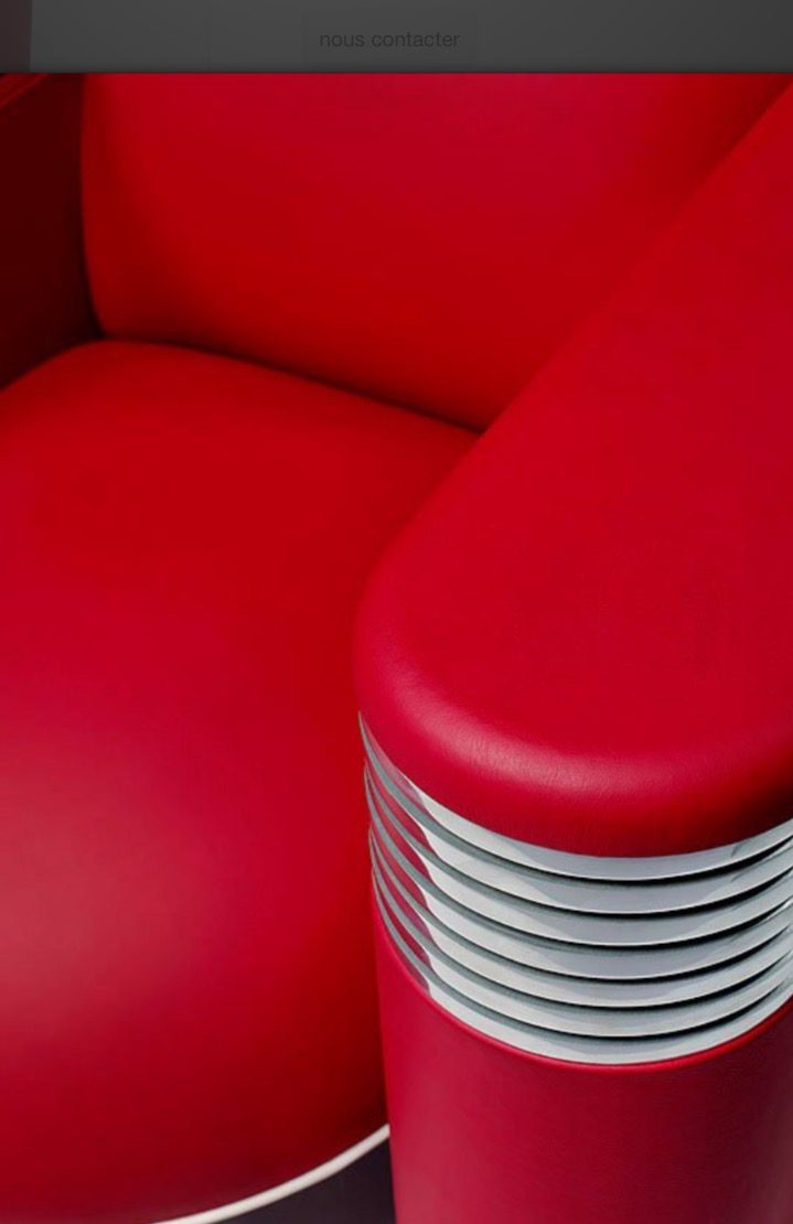 Un accoudoir en cuir rouge cerclé d'anneaux d'aluminium