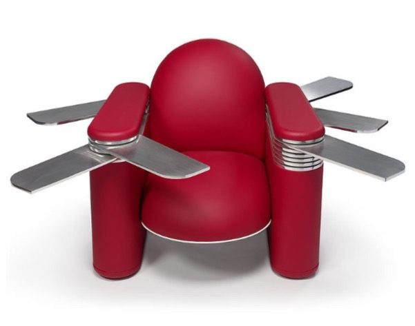 Le fauteuil en cuir rouge vu de face, des lames d'aluminium poli sorties des accoudoirs